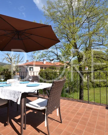 Terraza con mesa y vistas al jardín