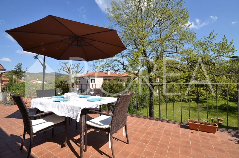 Terraza con mesa y vistas al jardín