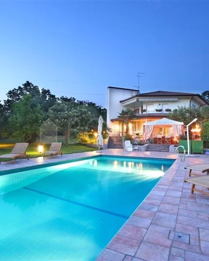 Piscina y villa al atardecer